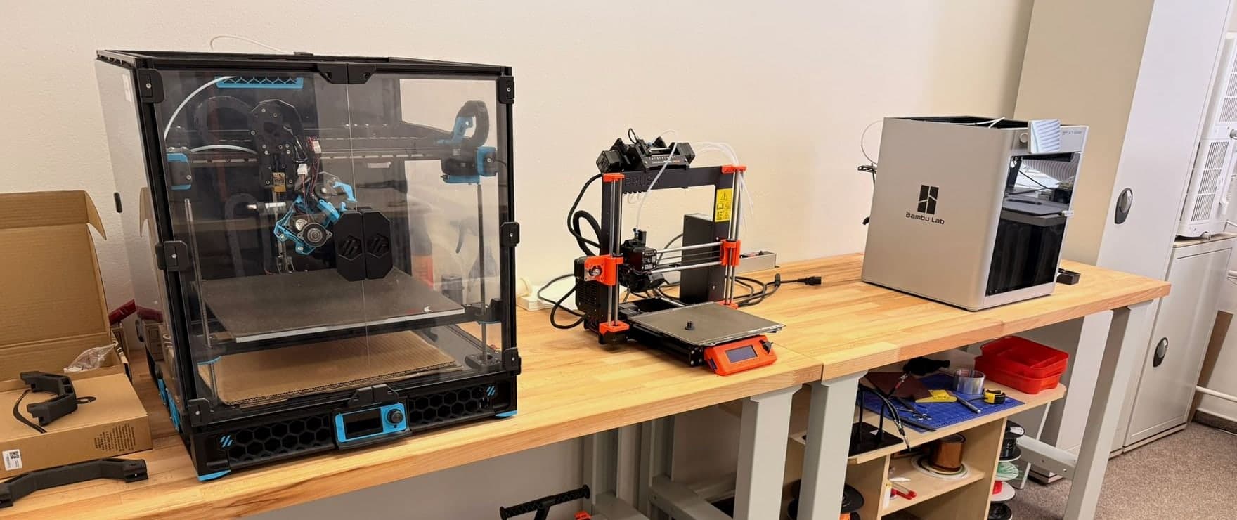 Voron, Original Prusa MK3S a Bambu Lab X1 Carbon na jednom stole v naší dílně — tři protokoly, jedna aplikace