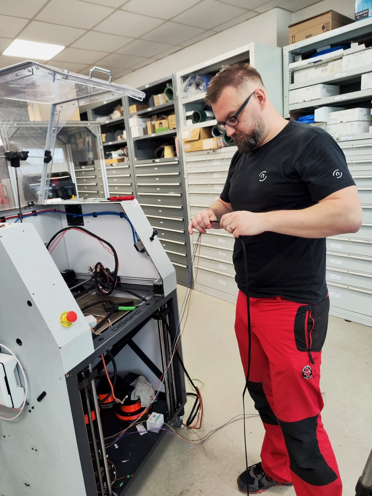 Technik nad otevřenou tiskárnou v servisní dílně při výměně kabeláže